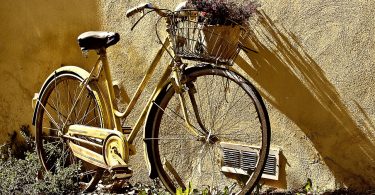 bicicletta gialla davanti a muro giallo