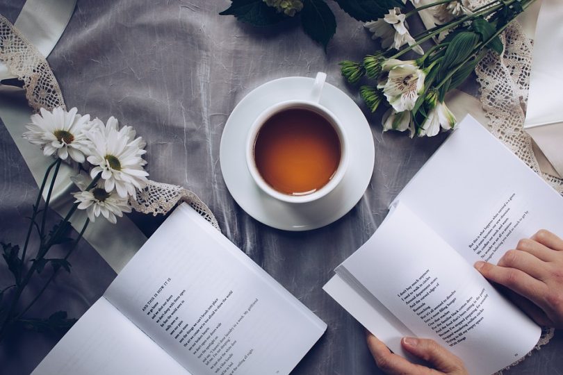 tazza di tè vicino a fiori e libri