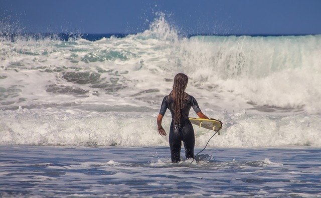 ragazza surfista tra le onde