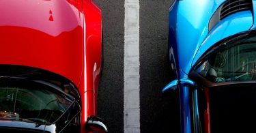auto blu e auto rossa posteggiate a fianco