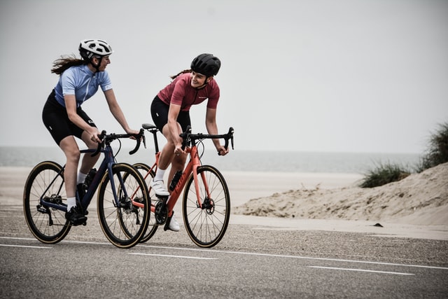 donne in mountan bike su strada vicino al mare