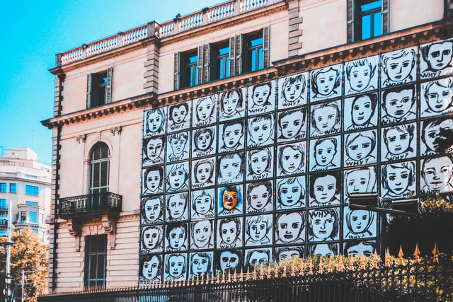 disegno di visi di persone sopra la parete di un edificio