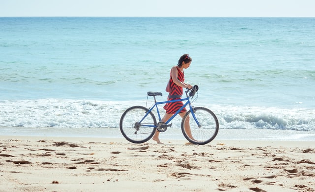 ragazza con bicicletta sulla spiaggia