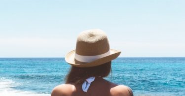 ragazza con cappello di fronte al mare