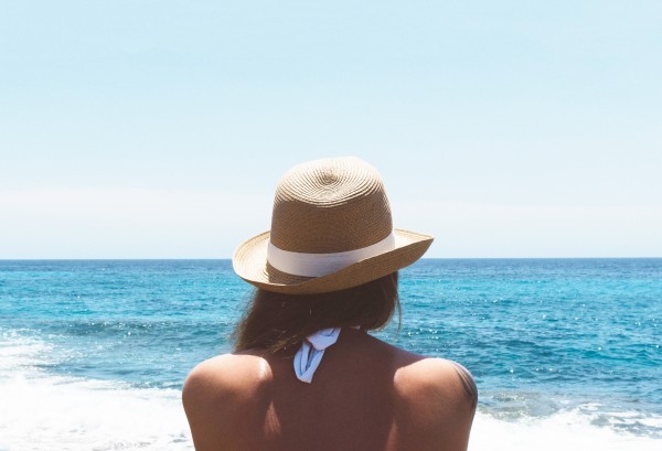 ragazza con cappello di fronte al mare