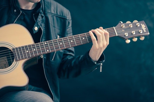 primo piano di mano che suona la chitarra