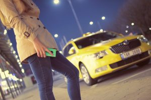 ragazza aspetta un taxi giallo