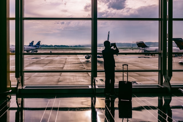 uomo fotografa aeroplani al tramonto in aeroporto