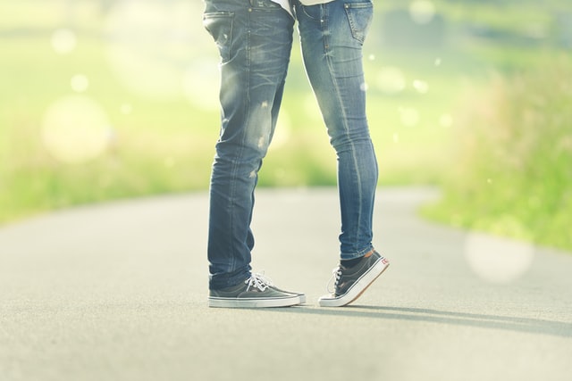 gambe di ragazzo e ragazza con jeans e scarpe vans