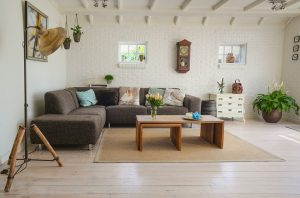 alt="soggiorno pareti bianche con divano marrone e tavolo in legno"