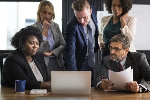 gruppo di persone in tailleur guarda computer