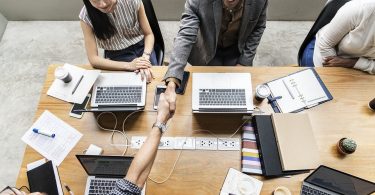 persone sedute intorno a tavolo con computer