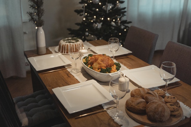 tavola apparecchiata per natale con pollo arrosto, pane e dolce