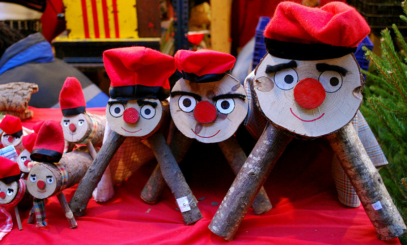 tronchi di legni decorati con occhi, bocca e un cappello rosso