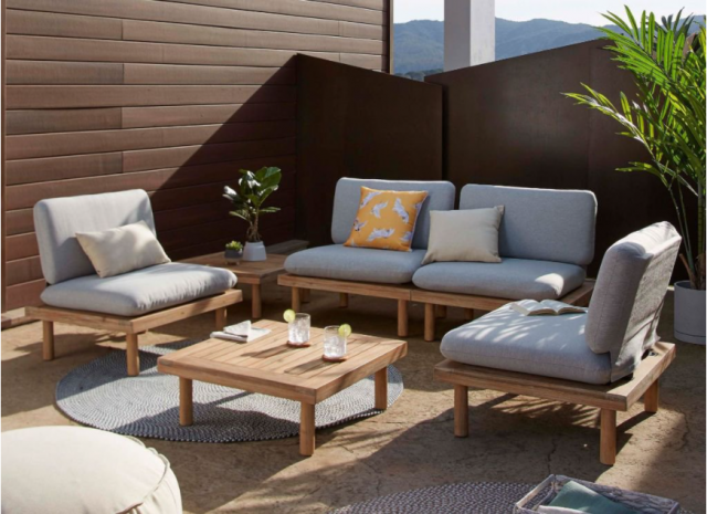 divano e poltroncine da esterno con tavolino in legno su terrazzo