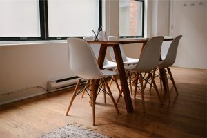 sedie bianche intorno a tavolo di legno su parquet
