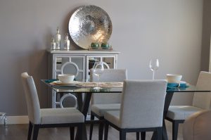 tavolo di cristallo con sedie grigie e bicchieri