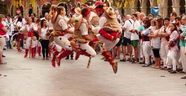 alt="persone in costume tradizionale che saltano"