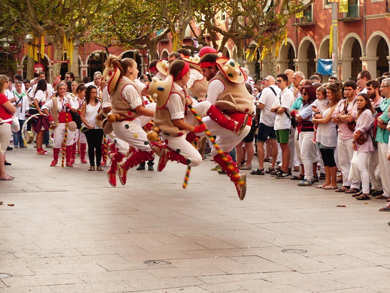 alt="persone in costume tradizionale che saltano"
