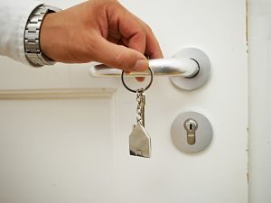 mano apre porta bianca con chiavi
