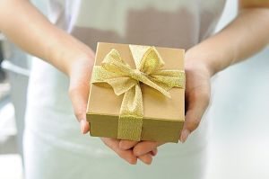 mani di donna con pacchetto dorato