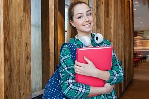 ragazza con camicia a quadri zaino e quaderno rosso