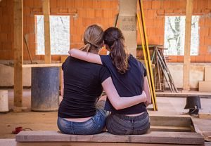 ragazze si abbracciano davanti lavori casa