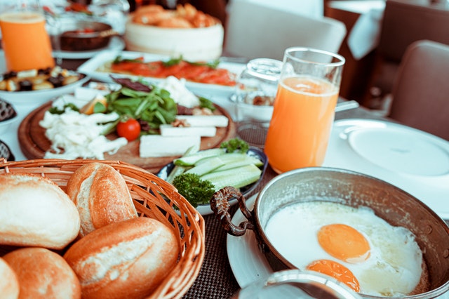 tavola imbandita con uova pane succo d'arancia e altri piatti con cibo