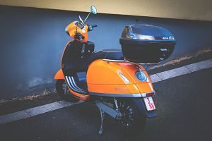 scooter arancione parcheggiato davanti a un muro