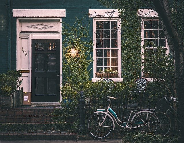 bicicletta davanti a facciata di casa blu con finestre e porta