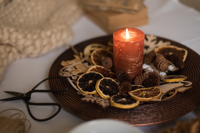 candela rossa su piatto con fiori secchi