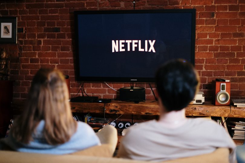 ouomo e donna su divano guardano netflix