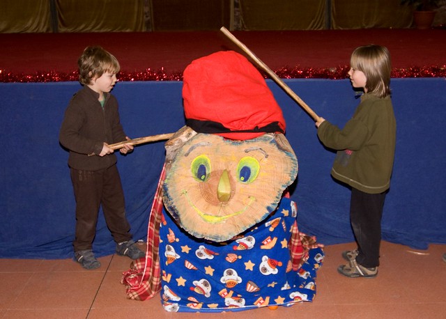 due bambini colpiscono un tronco di legno con dei bastoni