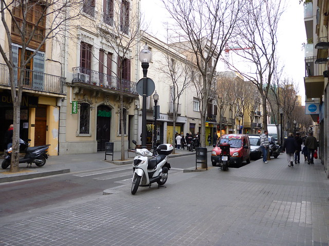 strada di quartiere con scooter e macchine parcheggiate