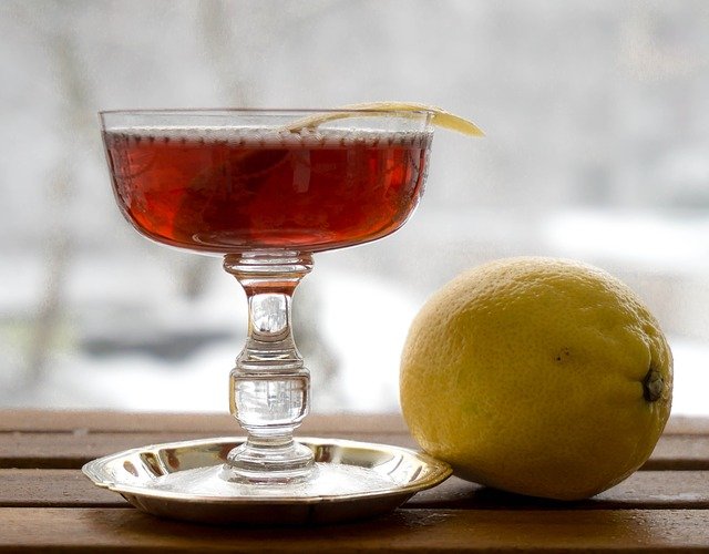 bicchiere con cocktail rosso e limone intero a fianco