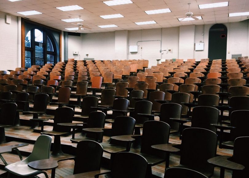 aula di università con sedie di legno vuota