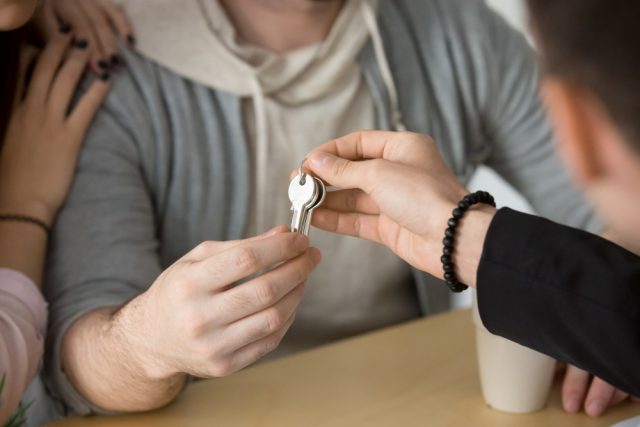 primo piano di mani di persone che si passano delle chiavi di casa