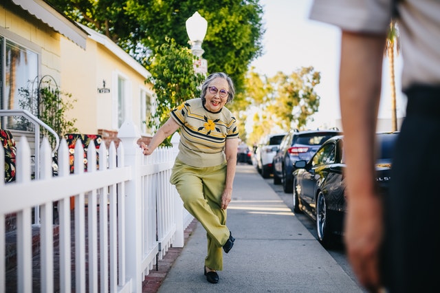 signora anziana sorride per la strada