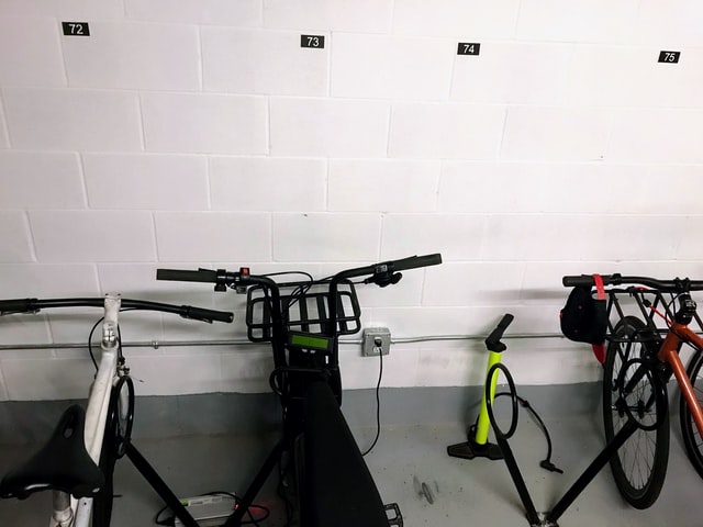 biciclette posteggiate davanti a una parete di mattoni bianchi