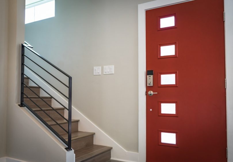 ingresso di una casa con portone rosso e scale