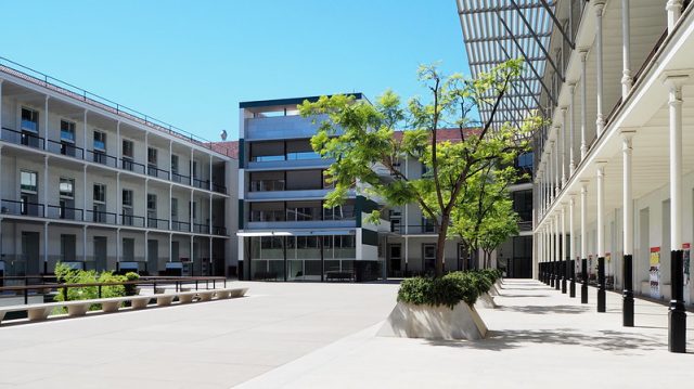 edificio moderno con patio centrale con alberi e panchine