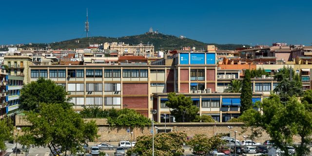 edificio in mattoni con finestre davanti a una collina