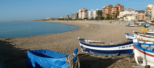barche blu e bianche su spiaggia con palazzi sullo sfondo
