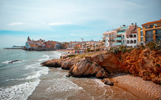 spiaggia con rocce ed edifici sullo sfondo