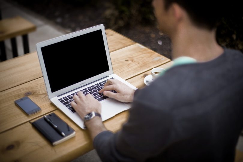 ragazzo scrive su computer portatile