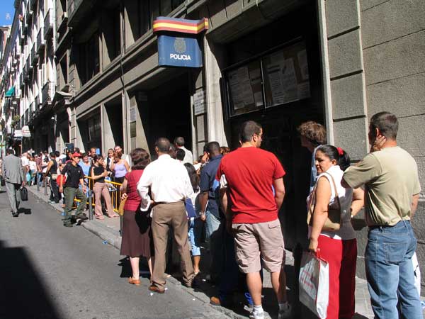 persone in fila davanti a un commissariato spagnolo